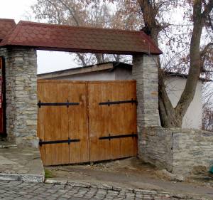 Деревянные ворота во двор под черепичной крышей