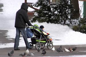 Папа гуляет с ребенком в коляске зимой