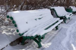 Ряд лавок в парке под снегом 