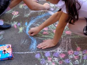 дети рисуют картину мелом на асфальте
