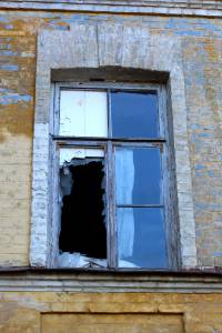 старое окно с разбитыми стеклами 