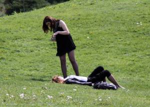Девушка фотографирует девушку на траве