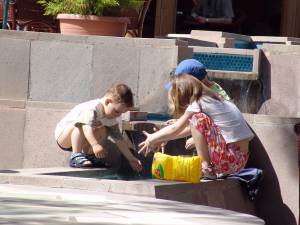 Дети играют у фонтана